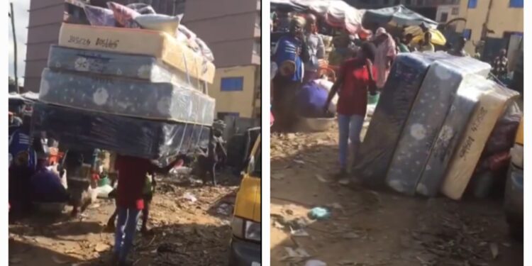 Kayayei spotted struggling to carry four stacked mattresses